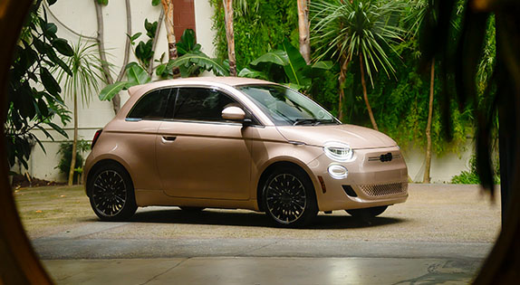 Un ángulo del lado del pasajero de un FIAT 500e 2025 color oro rosa.