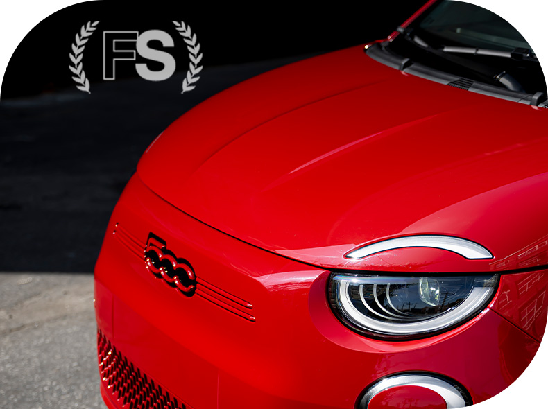 El logotipo de la Sociedad Fiat y el frontal en ángulo de un Fiat 500e rojo de 2024. Inspirado.