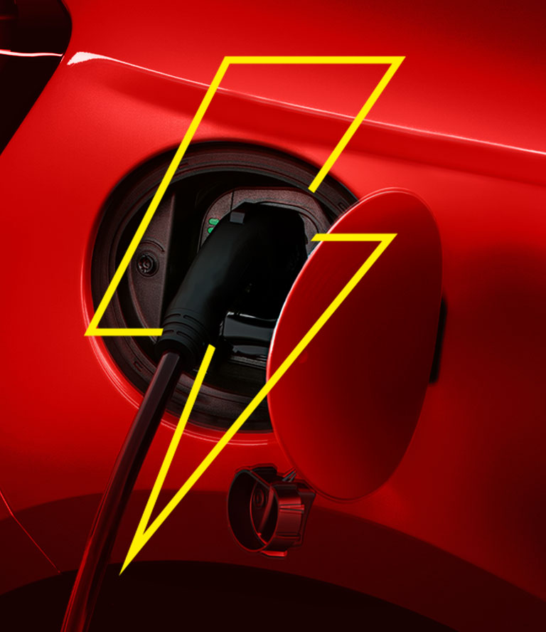 El puerto de carga en el Fiat 500e 2024 con un cable de carga conectado.