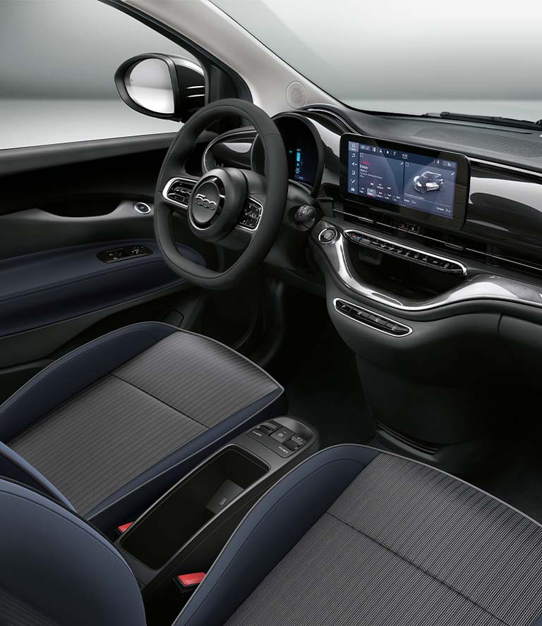 Interior del Fiat 500e La Prima de 2024, con especial atención a la guía, la pantalla táctil Uconnect y el tablero.